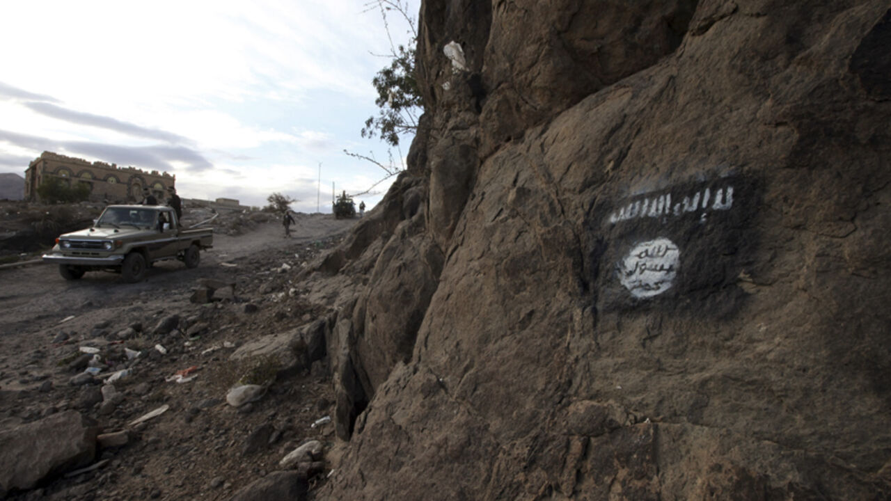 Shi'ite Houthi rebels drive a patrol truck past a Ansar al-Sharia flag painted on the side of a hill, along a road in Almnash, the main stronghold of Ansar al-Sharia, in Rada November 22, 2014. Shi'ite Houthi fighters recently managed to enter the area, which had long been the main stronghold of Ansar al-Sharia, the local wing of Al Qaeda in the Arabian Peninsula (AQAP). Picture taken November 22, 2014. REUTERS/Mohamed al-Sayaghi (YEMEN - Tags: CIVIL UNREST TPX IMAGES OF THE DAY CONFLICT) - RTR4F880