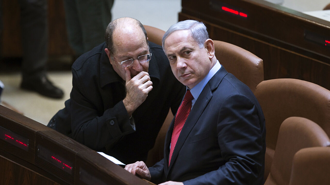 MIDEAST-ISRAEL/POLITICS Israel's Defence Minister Moshe Yaalon (L) speaks with Prime Minister Benjamin Netanyahu during a session of the Knesset, the Israeli parliament, in Jerusalem December 1, 2014. Netanyahu, enmeshed in a cabinet crisis, said on Monday he would call an early national election unless rebellious ministers stopped attacking government policies. REUTERS/Ronen Zvulun (JERUSALEM - Tags: POLITICS MILITARY) - RTR4GAPY