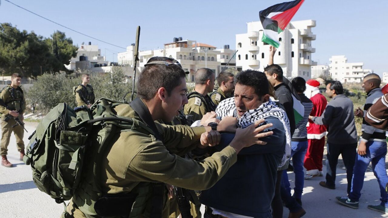 Palestinian protester scuffles with an Israeli soldier during a protest against Israeli settlements in Maasara village near the West Bank city of Bethlehem A Palestinian protester scuffles with an Israeli soldier during a protest against Israeli settlements in Maasara village near the West Bank city of Bethlehem December 26, 2014. REUTERS/ Mussa Qawasma (WEST BANK - Tags: POLITICS CIVIL UNREST TPX IMAGES OF THE DAY) - RTR4JAOJ