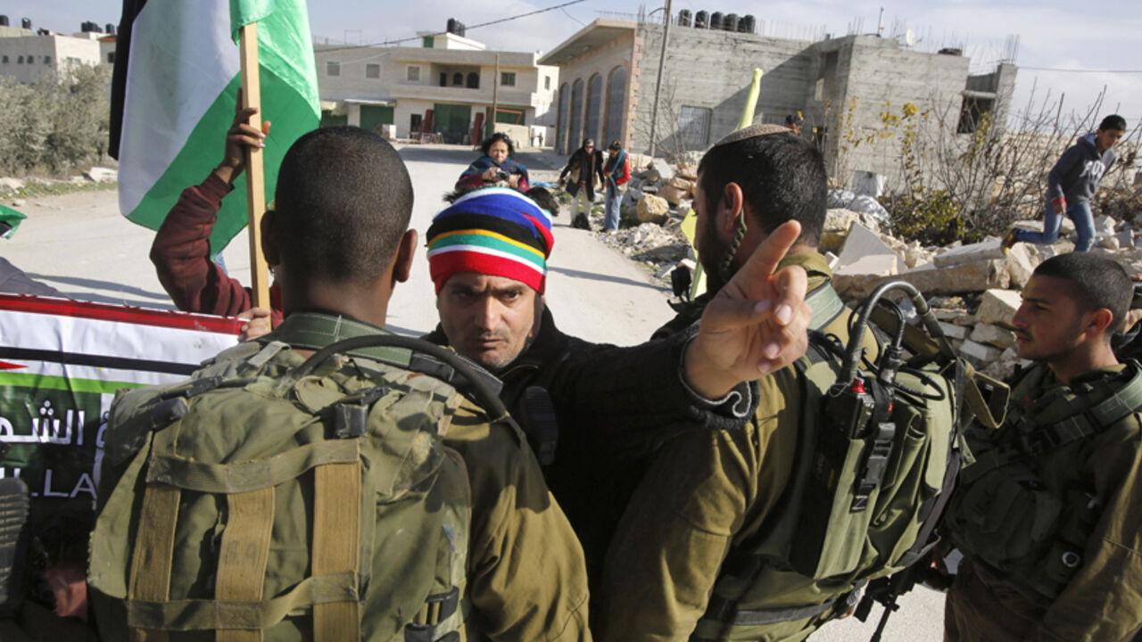 A Palestinian protester argues with Israeli soldiers during a weekly protest against Israeli settlements in the village of Maasara, near the West Bank city of Bethlehem, January 2, 2015. 
REUTERS/ Mussa Qawasma (WEST BANK  - Tags: CIVIL UNREST MILITARY POLITICS) - RTR4JW3V