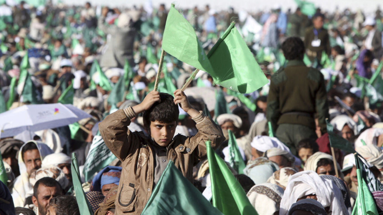 YEMEN-RELIGION/ A boy holds up flags of the Shi'ite Houthi movement during a ceremony commemorating the birth of Prophet Mohammed in Sanaa January 3, 2015. REUTERS/Mohamed al-Sayaghi (YEMEN - Tags: RELIGION ANNIVERSARY) - RTR4JYNI