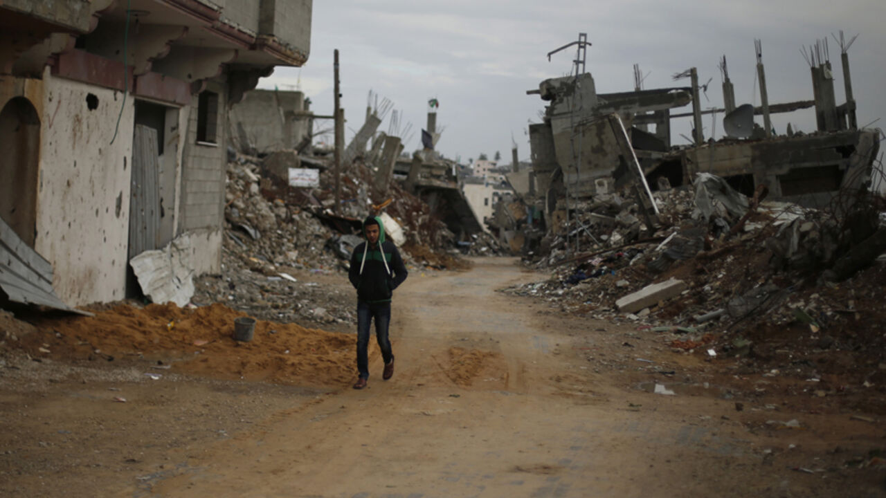 MIDEAST-PALESTINIANS/ISRAEL A Palestinian walks near the remains of houses, that witnesses said were destroyed or damaged by Israeli shelling during the July-August war between Israel and Hamas-led Gaza militants, in the east of Gaza City January 4, 2015. REUTERS/Suhaib Salem (GAZA - Tags: POLITICS CIVIL UNREST) - RTR4K02O