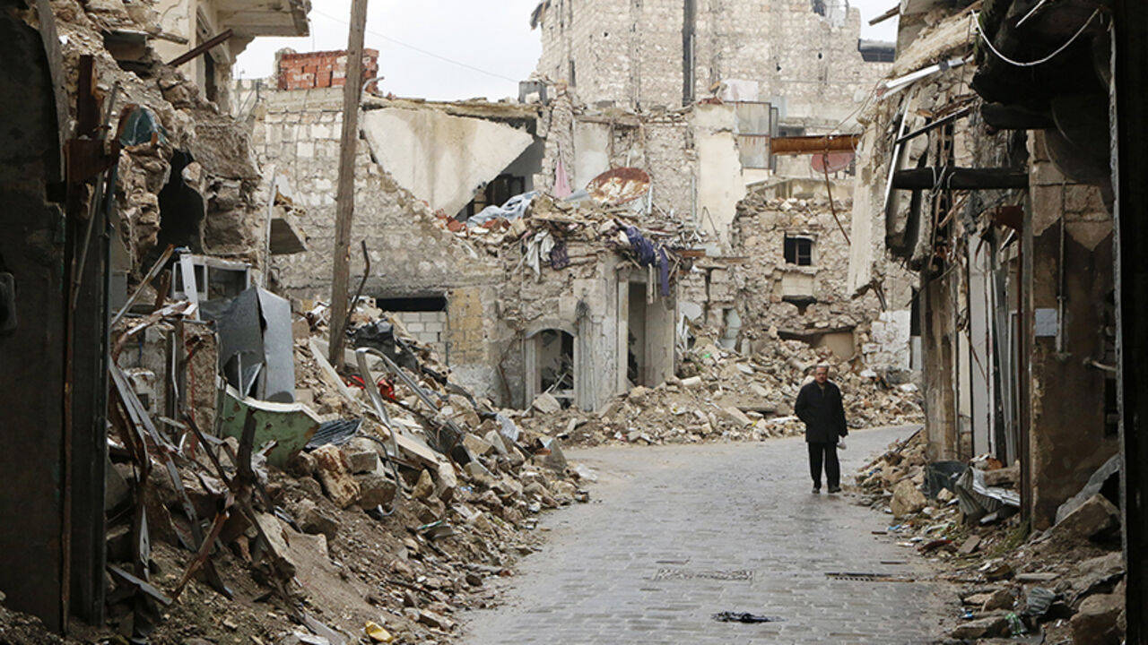A man walks through a damaged street beside a frontline in Old Aleppo January 4, 2015. REUTERS/Hosam Katan (SYRIA - Tags: POLITICS CIVIL UNREST CONFLICT) - RTR4K1CI