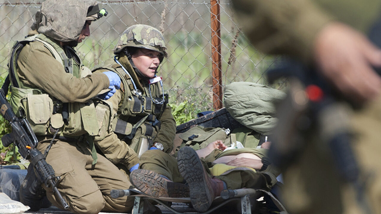 MIDEAST-ISRAEL/LEBANON A wounded Israeli soldier lies on a stretcher near Israel's border with Lebanon January 28, 2015. The threat of a full-blown conflict between Israel and Hezbollah increased on Wednesday after the Lebanese militant group fired a missile at an Israeli army vehicle along the frontier and wounded seven soldiers, the biggest escalation since a 2006 war. REUTERS/JINIPIX (ISRAEL - Tags: MILITARY POLITICS CIVIL UNREST) ISRAEL OUT. NO COMMERCIAL OR EDITORIAL SALES IN ISRAEL - RTR4NB95