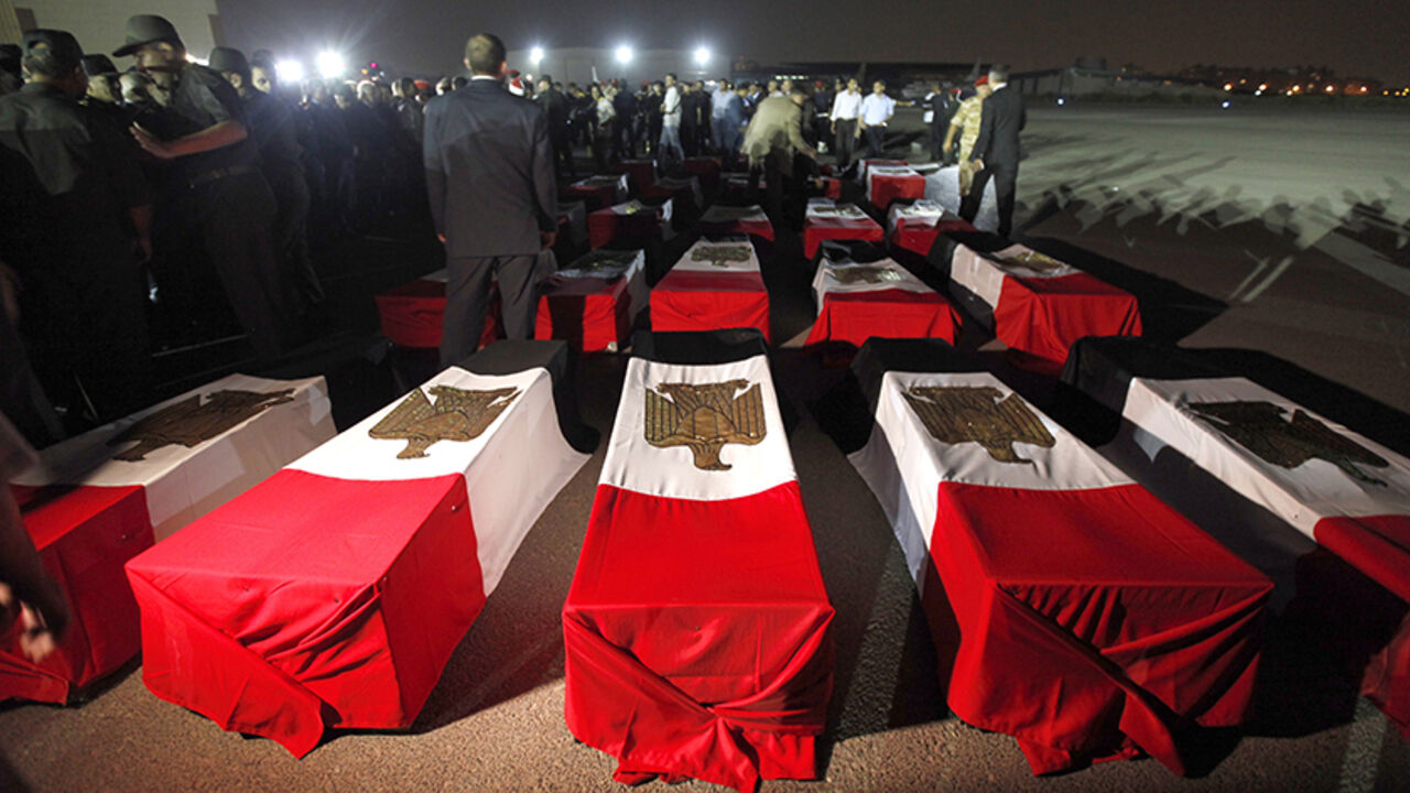 The caskets of 25 policemen killed early Monday morning near the north Sinai town of Rafah lay on the ground after arriving at Almaza military airport in Cairo August 19, 2013. The 25 Egyptian policemen were killed and three others wounded in an ambush by Islamist militants, medical and security sources said. Attacks by Islamist militants in the lawless north Sinai region have intensified since the army overthrew Islamist President Mohamed Mursi on July 3. REUTERS/Mohamed Abd El Ghany (EGYPT - Tags: POLITIC