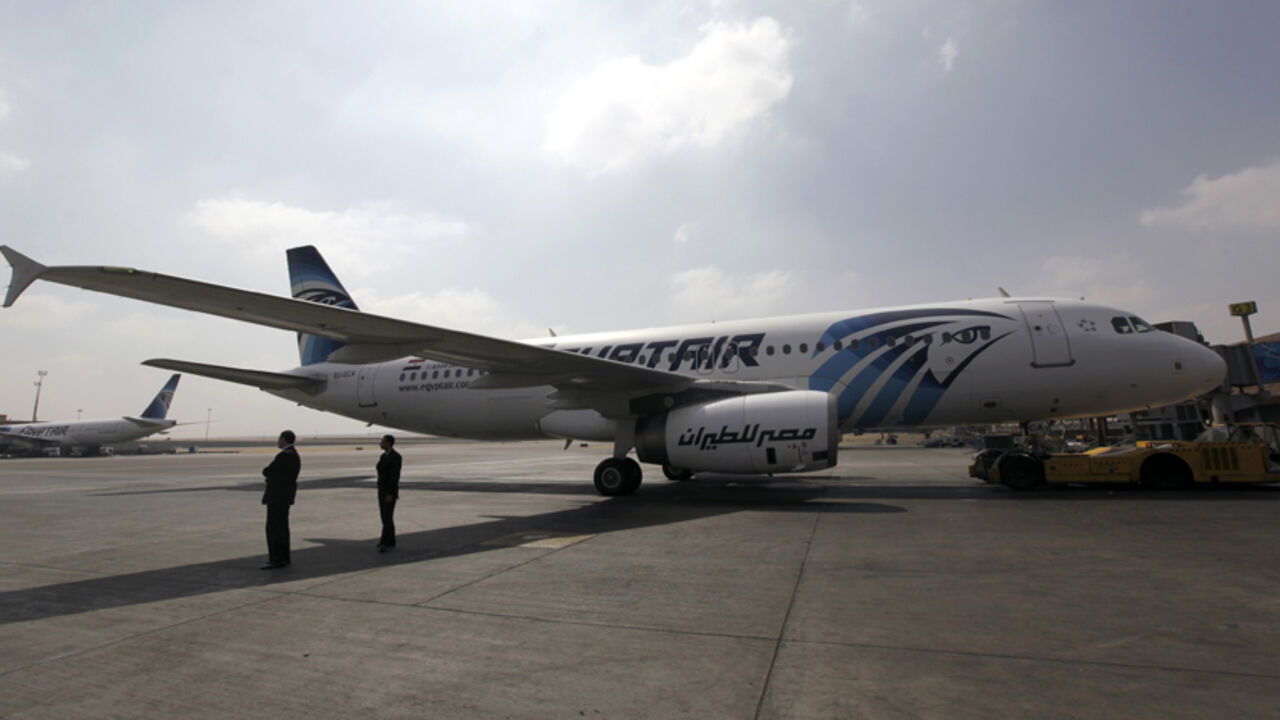 Airport staff stand next to an EgyptAir plane on the runway at Cairo Airport, September 5, 2013. The ongoing political crisis in Egypt has hit the once vibrant tourism industry hard, devastating a critical part of the country's economy. And with visitors scared away by civil strife in the aftermath of the ouster of President Mohamed Mursi, Egypt's national airliner, EgyptAir has been hit hard by the tourism slowdown. The airline has taken the brunt of losses in the tourism sector, losing billions of pounds 
