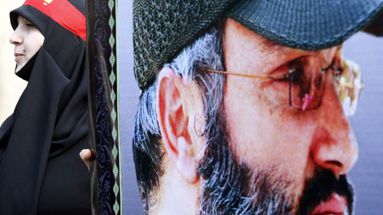 Nic520786 A woman supporter of the Shiite Muslim Hezbollah movement holds onto an image of the movement's slain commander Imad Mughniyeh during a Hezbollah parade in the city of Nabatiyeh in southern Lebanon on December 19, 2010, to mark the 13th day of Muharram-Ashura, where believers mourn the killing of the Prophet Mohammed's grandson, Imam Hussein, in the seventh century, during the battle of Karbala in central Iraq. AFP PHOTO/MAHMOUD ZAYYAT (Photo credit should read MAHMOUD ZAYAT/AFP/Getty Images)