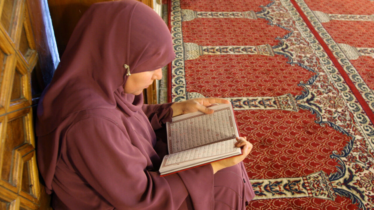 SYRIA / A Muslim woman reads the Koran before Iftar, when Muslims break their fast, during the holy month of Ramadan at the historic Umayyad Mosque in Old Damascus August 26, 2009. Muslims around the world abstain from eating, drinking and conducting sexual relations from sunrise to sunset during Ramadan, the holiest month in the Islamic calendar. REUTERS/Khaled al-Hariri (SYRIA SOCIETY RELIGION) - RTR274NK