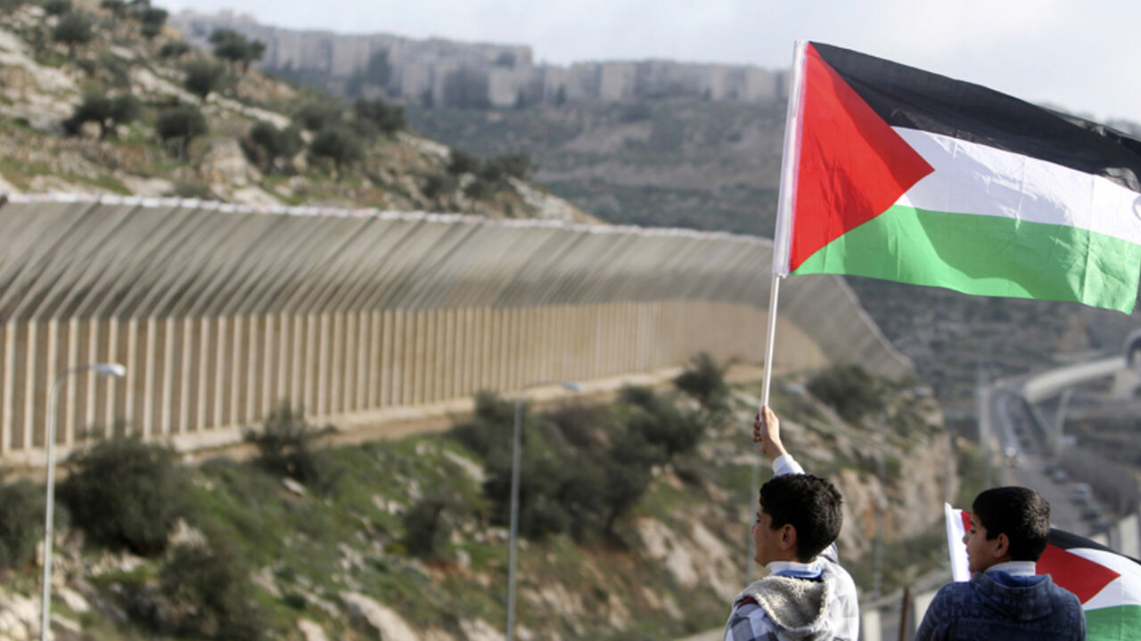 PALESTINIANS-ISRAEL/ Palestinian youths hold Palestinian flags during a demonstration against the construction of a section of the controversial Israeli barrier in the West Bank town of Beit Jala near Bethlehem March 4, 2010. REUTERS/Ammar Awad (WEST BANK - Tags: POLITICS CIVIL UNREST) - RTR2B7EQ
