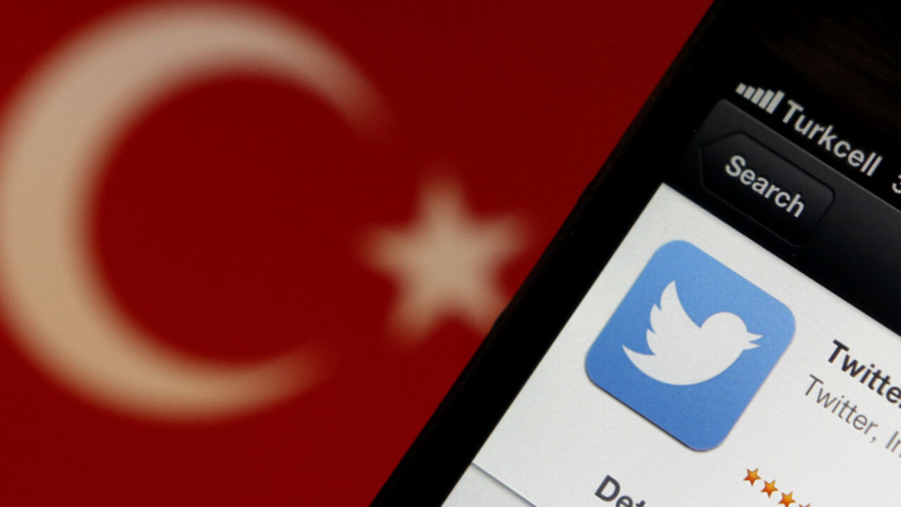 TURKEY-TWITTER/ A Twitter logo on an iPhone display is pictured next to a Turkish flag in this photo illustration taken in Istanbul March 21, 2014. Turkey's courts have blocked access to Twitter a little over a week before elections as Prime Minister Tayyip Erdogan battles a corruption scandal that has seen social media awash with alleged evidence of government wrongdoing. The ban came hours after a defiant Erdogan, on the campaign trail ahead of key March 30 local elections, vowed to "wipe out" Twitter and said he did not