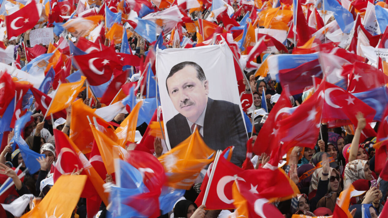Supporters hold up a portrait of Turkey's Prime Minister Tayyip Erdogan while waving Turkish and AK Party (AKP) flags during an election rally in Istanbul March 23, 2014. Erdogan, rallying hundreds of thousands of cheering supporters in Istanbul, said on Sunday that political enemies accusing him of corruption would be crushed by their own immorality. REUTERS/Murad Sezer (TURKEY - Tags: POLITICS ELECTIONS) - RTR3I96X