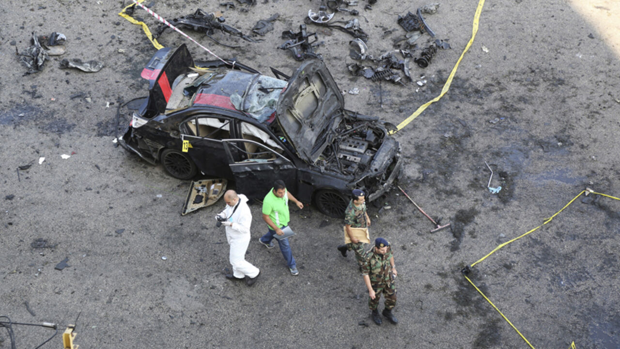 A Forensic inspector and Lebanese army soldiers work at a site of explosion that occured on Monday night in the southern suburbs of the Lebanese capital Beirut June 24, 2014. A suicide bomber blew up his car in Beirut on Monday night near an army checkpoint, killing a security officer and wounding several people watching the soccer World Cup in a nearby cafe. Security forces have been on high alert since a suicide bomber killed one person and wounded 37 near the Syrian border on Friday in an attack that nar