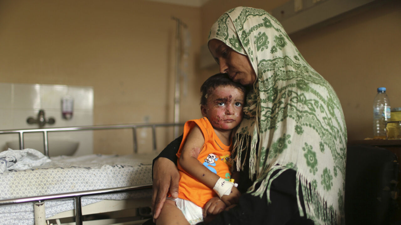 Palestinian boy Mohammed Wahdan, whom medics said was wounded in Israeli shelling, is held by his aunt as he receives psychological care at Shifa hospital in Gaza City August 14, 2014. In a ward at Shifa, Gaza's largest hospital, child therapist Rabeea Hamouda is trying to elicit a response from two small brothers, Omar and Mohammed, aged three and 18 months, hoping for some words or perhaps a smile. For seven straight minutes the children, peppered with burns and shrapnel wounds sustained in Israeli shelli