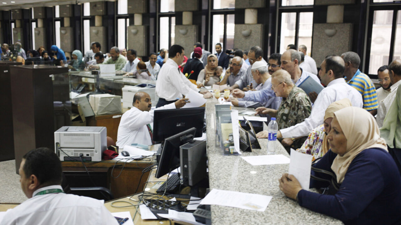 EGYPT-SUEZCANAL/ People buy Suez Canal investment certificates at a bank in Cairo September 4, 2014. Egypt issued government certificates to finance the Suez Canal project on Monday, state media said, as the country aims to expand trade along what is the fastest shipping route between Europe and Asia. The five-year investment certificates have a 12 percent interest rate and pay quarterly dividends and will come in 10, 100 and 1,000 Egyptian pound ($1.40-$140) denominations, MENA said. REUTERS/Asmaa Waguih (EGYPT - Tags: BUS