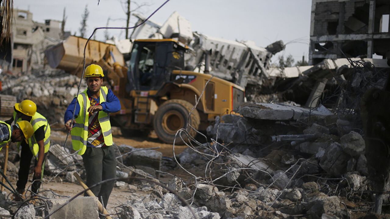 MIDEAST-GAZA/CONSTRUCTION Palestinian workers participate in efforts to clear the rubble of a school, that witnesses said was destroyed by Israeli shelling during the most recent conflict between Israel and Hamas, in the east of Gaza City, December 3, 2014. According to housing minister Mufeed al-Hasayna, Gaza needs 8,000 tonnes of cement a day to meet demand. A new system set up with the United Nations to comply with Israeli requirements lets through at most 2,000, he said. At that rate, reconstruction would take more than 30 years