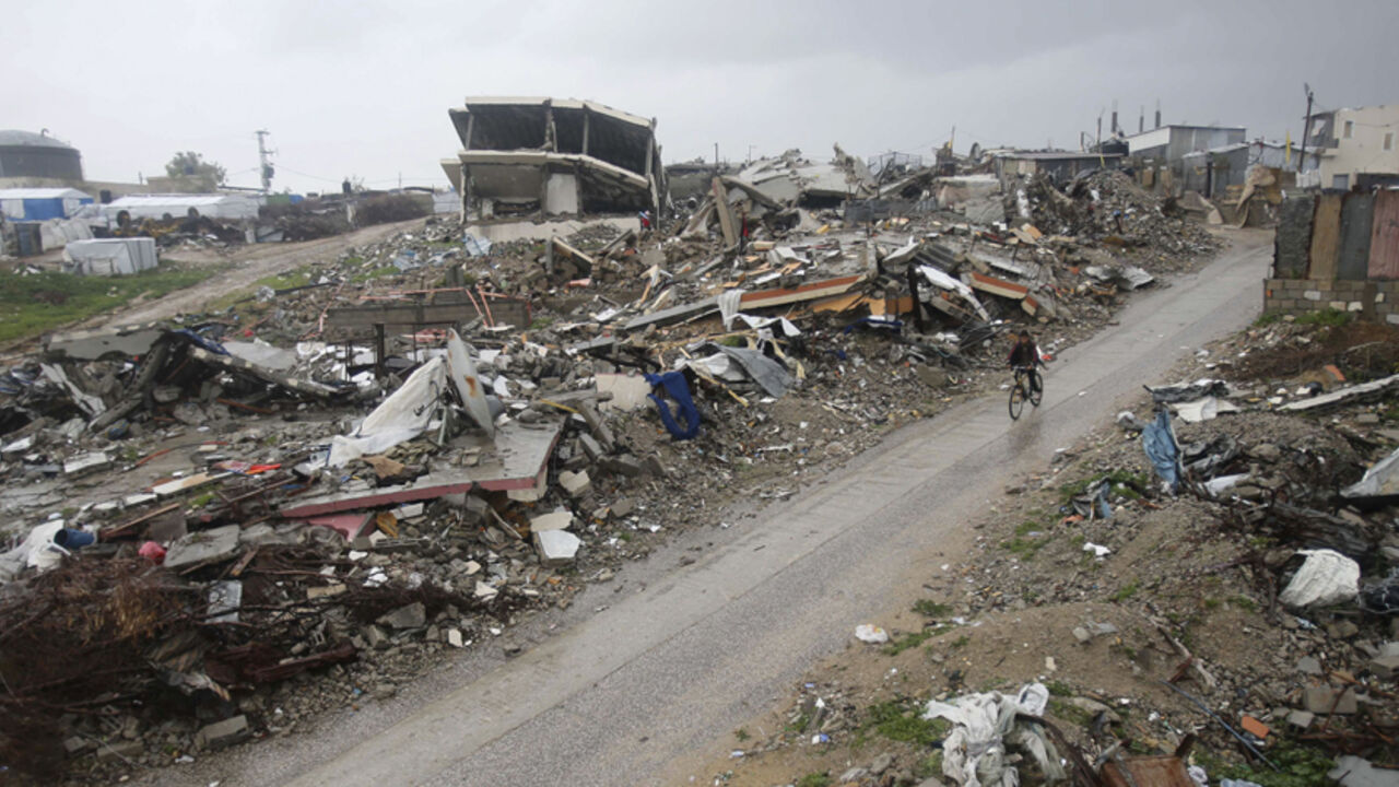 MIDEAST-STORM/ A Palestinian boy rides a bicycle past the ruins of houses that witnesses said were destroyed by Israeli shelling during a 50-day war last summer, on a rainy day in the village of Johar a-Deek near central Gaza Strip January 9, 2015. Heavy rains and near-freezing temperatures in the approaching storm threatened to deepen the misery in the Gaza Strip, where streets are still strewn with wreckage from a 50-day war with Israel last summer, thousands live in U.N. shelters and damaged homes and the power is on o