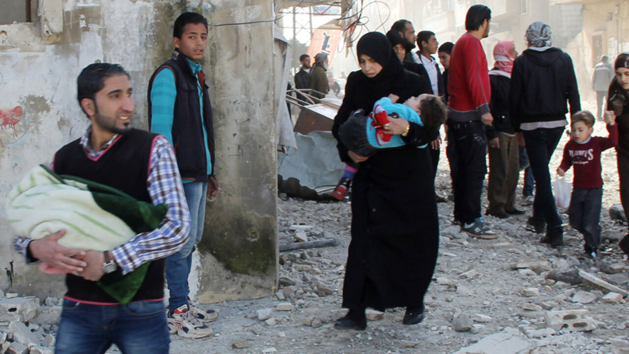 SYRIA-CRISIS/ Civilians carry their children as they flee, after what activists said were two barrels bombs dropped by forces loyal to Syria's President Bashar al-Assad, in the northwestern Homs district of Al Waer, February 7, 2015. REUTERS/Stringer (SYRIA - Tags: POLITICS CIVIL UNREST CONFLICT) - RTR4OLPY