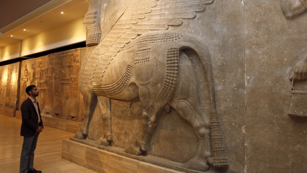 MIDEAST-CRISIS/IRAQ-MUSEUM A man looks at ancient Assyrian human-headed winged bull statues at the Iraqi National Museum in Baghdad February 28, 2015. REUTERS/Khalid al-Mousily (IRAQ - Tags: POLITICS) - RTR4RIZ3