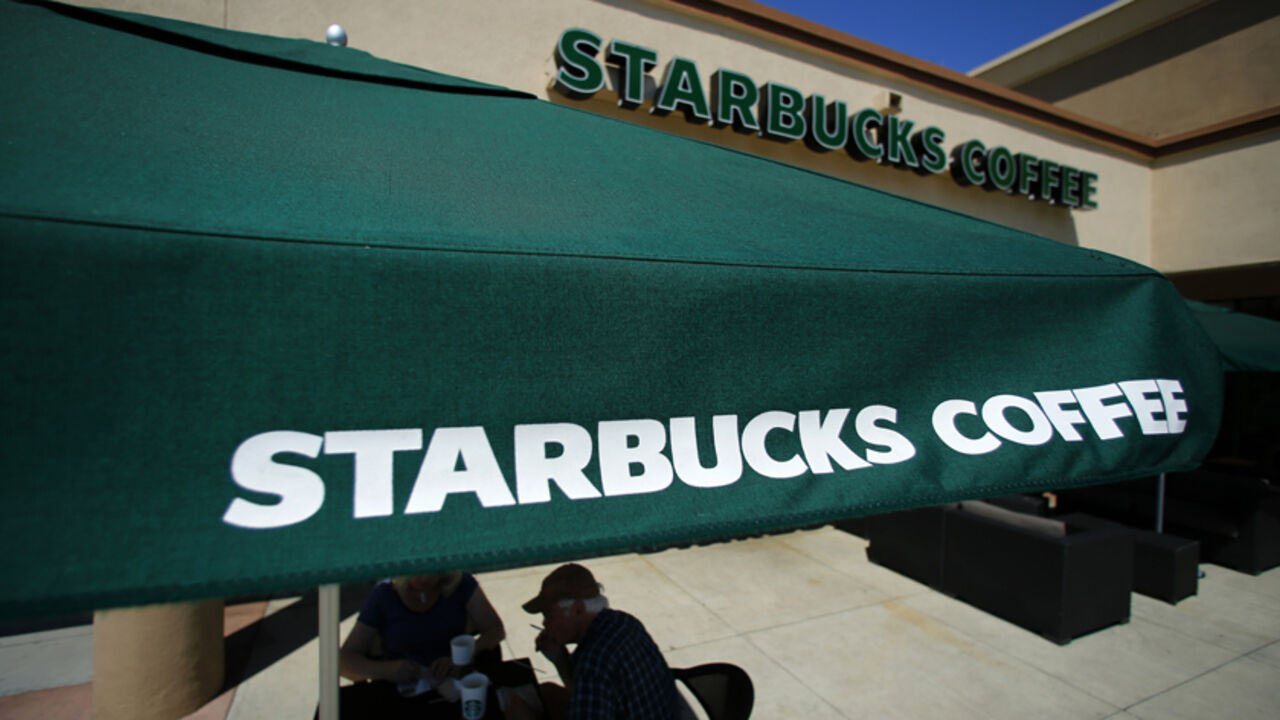 USA-STARBUCKS/ Customers enjoy their drinks outside a newly designed Starbucks coffee shop in Fountain Valley, California August 22, 2013. REUTERS/Mike Blake (UNITED STATES - Tags: BUSINESS FOOD) - RTX12TYM