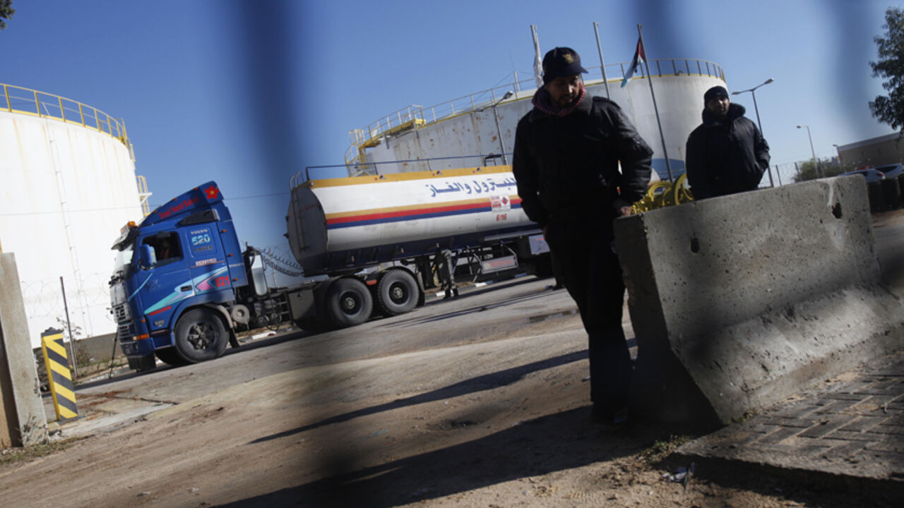 PALESTINIANS-GAZA/FUEL Palestinian policemen loyal to Hamas keep guard as a fuel tanker arrives to Gaza's power plant in the central Gaza Strip December 15, 2013. Israel allowed the entry of 450,000 litres (119,000 U.S. gallons) of fuel, paid for by Qatar, into the Gaza Strip on Sunday to enable the Palestinian territory's sole power plant to resume operations. REUTERS/Ibraheem Abu Mustafa (GAZA - Tags: ENERGY SOCIETY) - RTX16JDL