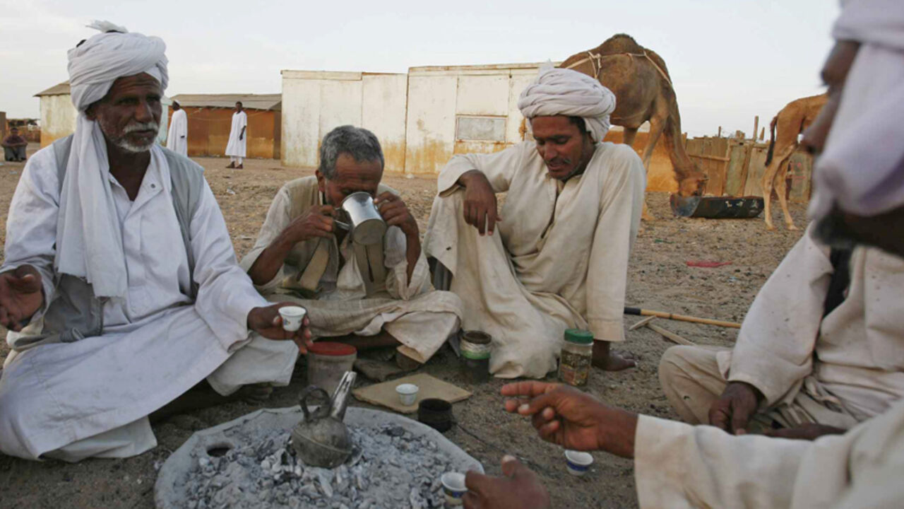 EGYPT/ Men from the Baja tribe drink Gabana or traditional coffee, in front of their huts in the Egyptian town of Shelatine, 1,060 km (659 miles) south of Cairo, April 22, 2009. REUTERS/Asmaa Waguih (EGYPT SOCIETY TRAVEL) - RTXE9O4