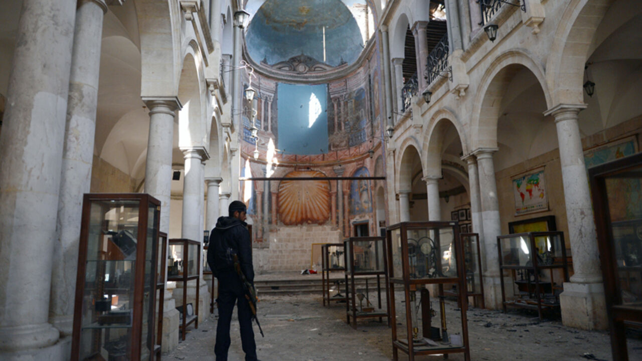 Nic6177221 A Syrian rebel looks at damaged display cases inside a former church turned into a film museum which was shelleld by government forces in Aleppo's old city on January 17, 2013. Rebels trying to break a months-long deadlock in their battle for Syria's second city Aleppo say they are cutting supply routes ahead of simultaneous assaults on regime bases. AFP PHOTO/AAMIR QURESHI (Photo credit should read AAMIR QURESHI/AFP/Getty Images)