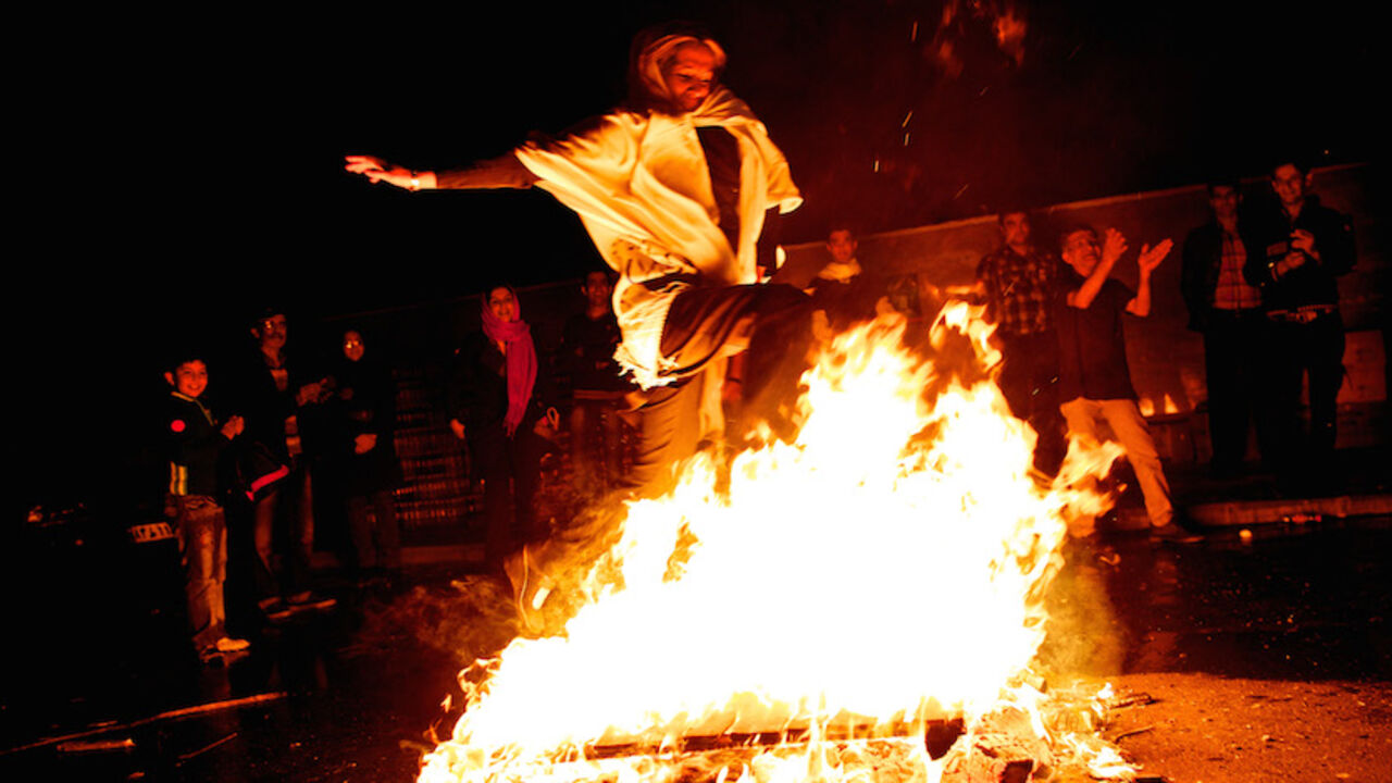 IRAN-NORUZ-FESTIVAL An Iranian woman jumps over a bonfire in southern Tehran on March 19, 2013 during the Wednesday Fire feast, or Chaharshanbeh Soori, held annually on the last Wednesday eve before the Spring holiday of Noruz. The Iranian new year that begins on March 20 coincides with the first day of spring during which locals revive the Zoroastrian celebration of lighting a fire and dancing around the flame. AFP PHOTO/BEHROUZ MEHRI (Photo credit should read BEHROUZ MEHRI/AFP/Getty Images)