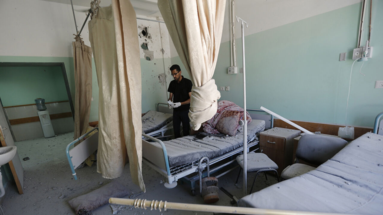 Nic6352130 A Palestinian employee inspects damages at the Al-Aqsa Martyrs hospital in Deir al-Balah, in the central Gaza Strip, after the building was shelled by the Israeli army on July 21, 2014, killing five people and wounding at least 70. World efforts to end two weeks of deadly violence in and around Gaza stepped up a gear as the UN chief arrived in Cairo and the top US diplomat was awaited. AFP PHOTO / MOHAMMED ABED (Photo credit should read MOHAMMED ABED/AFP/Getty Images)