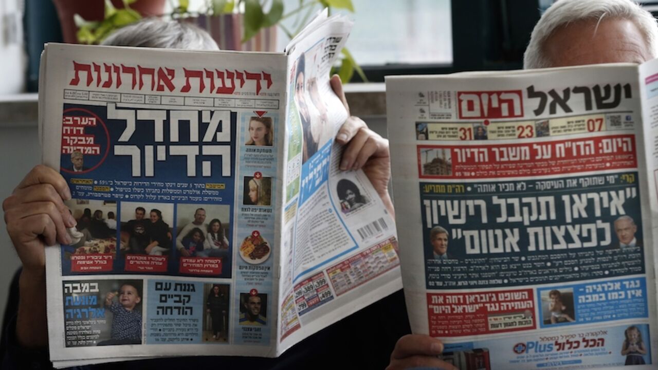 ISRAEL-VOTE-MEDIAS TO GO WITH AFP STORY BY JEAN-LUC RENAUDIE - Men read Israeli newspapers, paying daily Yedioth Aharonot (L) and free daily Israel HaYom (R) in Jerusalem, on February 25, 2015. As politicians intensify their campaigning for Israeli snap elections, an equally ferocious battle is playing out between two media tycoons -- a friend and a foe of Prime Minister Benjamin Netanyahu. AFP PHOTO / THOMAS COEX (Photo credit should read THOMAS COEX/AFP/Getty Images)