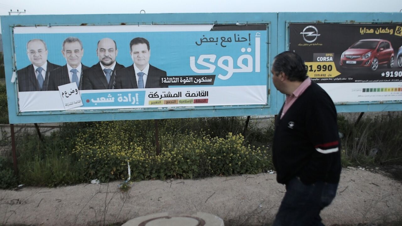 ISRAEL-POLITICS-VOTE An Israeli Arab walks past a campaign poster showing Israeli-Arab candidates who are members of a joint list of Arab parties (from L to R), Ahmad Tibi, Jamal Zahalka, Masud Ghanayem and Ayman Odeh, in Kfar Menda, 16 kilometres northwest of the city of Nazareth, on March 8, 2015. General elections in Israel are to take place on March 17. AFP PHOTO / AHMAD GHARABLI (Photo credit should read AHMAD GHARABLI/AFP/Getty Images)