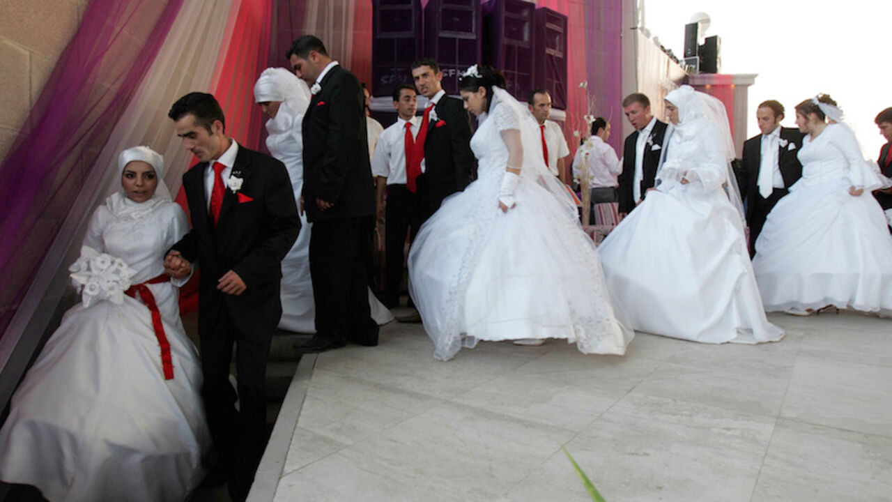 Brides and bridegrooms leave the stage during their wedding ceremony in Ankara Brides and bridegrooms leave the stage during their wedding ceremony in Ankara, August 6, 2006. 206 couples married together with an annual ceremony organised by Ankara municipality. REUTERS/Umit Bektas (TURKEY) - RTR1G5N0