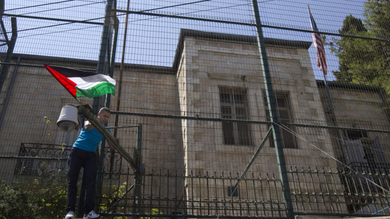 A man places a Palestinian flag on a fence surrounding the U.S. consulate during a rally in support of Palestinian President Mahmoud Abbas' bid for statehood recognition in the United Nations, in Arab East Jerusalem September 21, 2011. Abbas plans on Friday to submit an application for full U.N. membership for the state of Palestine based in the West Bank, East Jerusalem and the coastal Gaza Strip -- lands occupied by Israel in 1967. REUTERS/Ronen Zvulun (JERUSALEM - Tags: POLITICS) - RTR2RM9T