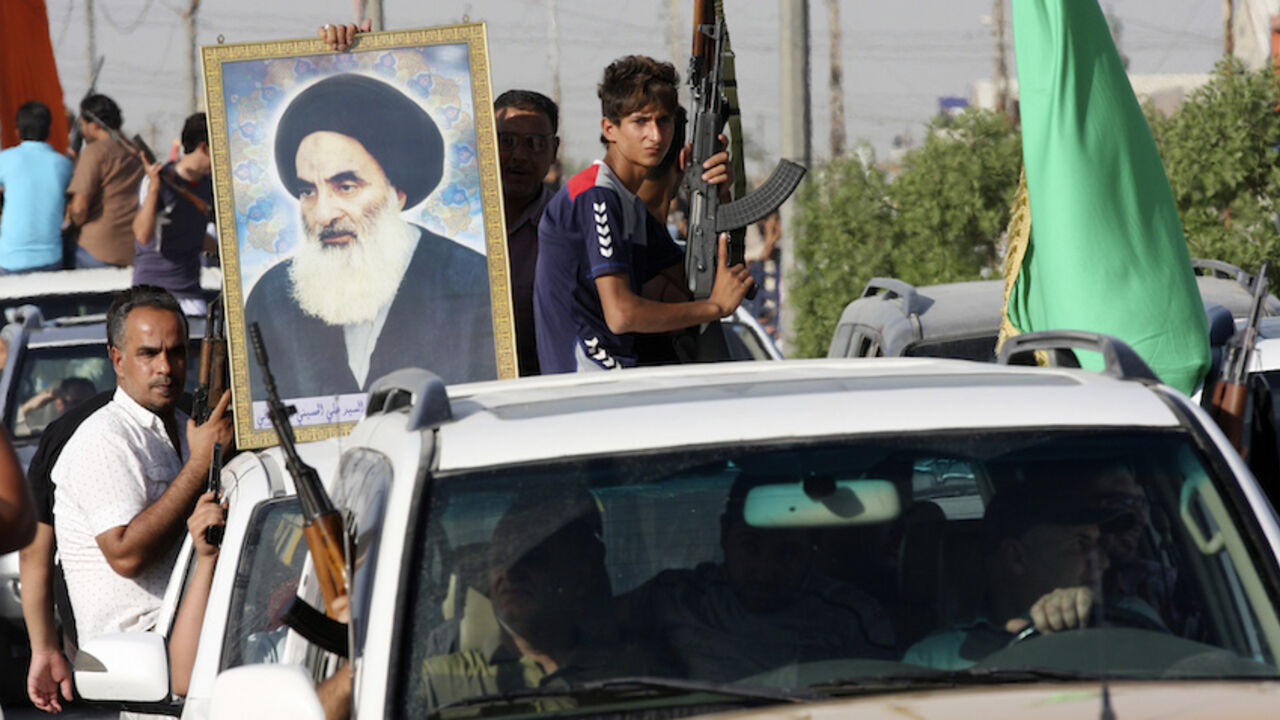 Volunteers, who have joined the Iraqi Army to fight against predominantly Sunni militants, carry weapons and a portrait of Grand Ayatollah Ali al-Sistani during a parade in Sadr city Volunteers, who have joined the Iraqi Army to fight against predominantly Sunni militants, carry weapons and a portrait of Grand Ayatollah Ali al-Sistani during a parade in the streets in Baghdad's Sadr city June 14, 2014. An offensive by insurgents that threatens to dismember Iraq seemed to slow on Saturday after days of lightning advances as government forces regained some territory in counter-attacks, easing pressure on the Shi'ite-led government in Baghdad. REUTERS/Wissm al-Okili (IRAQ - Tags: CIVIL