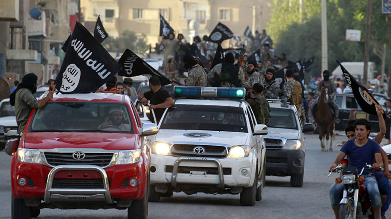 SYRIA-CRISIS/ Militant Islamist fighters waving flags, travel in vehicles as they take part in a military parade along the streets of Syria's northern Raqqa province June 30, 2014. The fighters held the parade to celebrate their declaration of an Islamic "caliphate" after the group captured territory in neighbouring Iraq, a monitoring service said. The Islamic State, an al Qaeda offshoot previously known as Islamic State in Iraq and the Levant (ISIL), posted pictures online on Sunday of people waving black flags from car