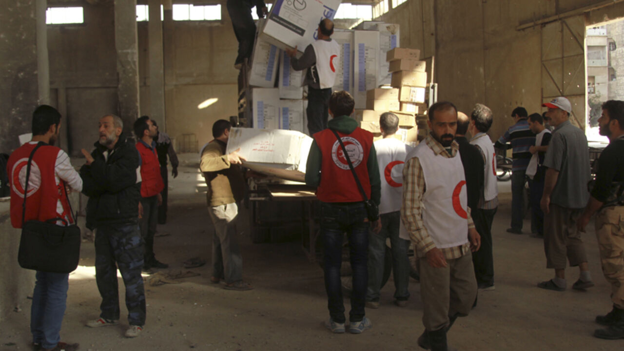 SYRIA-CRISIS/ Workers and members of the Syrian Arab Red Crescent unload boxes of humanitarian and medical aid in the rebel-controlled area of Aleppo's Bustan al-Qasr October 28, 2014. REUTERS/Ammar Abdullah (SYRIA - Tags: POLITICS CIVIL UNREST CONFLICT) - RTR4BWB4
