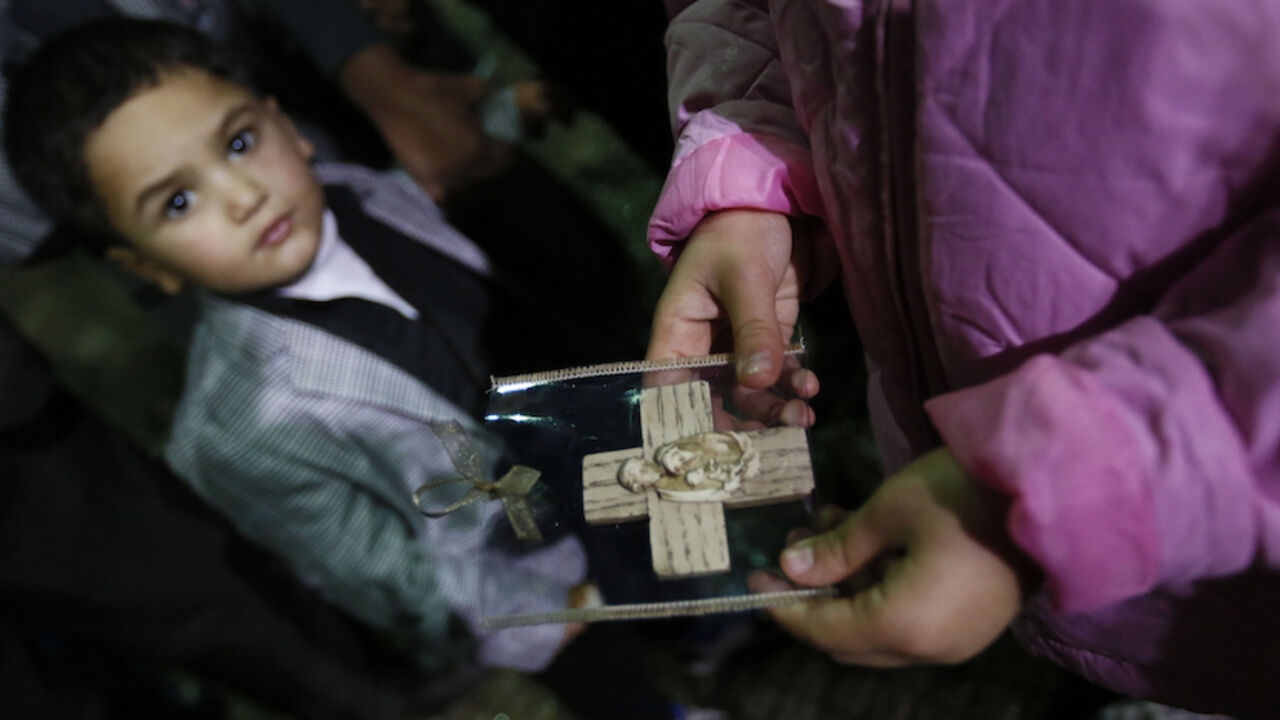 An Iraqi Christian refugee girl holds a souvenir of the Holy Family as a boy looks on at a church in Hazmiyeh An Iraqi Christian refugee girl holds a souvenir of the Holy Family as a boy looks on at a church in Hazmiyeh, near Beirut December 12, 2014. Christian leaders led the service for around 600 Iraqi Christian refugees, many of them children and the elderly. Iraqi Christians who sought refuge in Lebanon after Islamist militants tore through their homeland said they had no idea when they would be able to return as they gathered for prayers ahead of Christmas. Picture taken December 12, 2014. REUTERS/Jamal Saidi