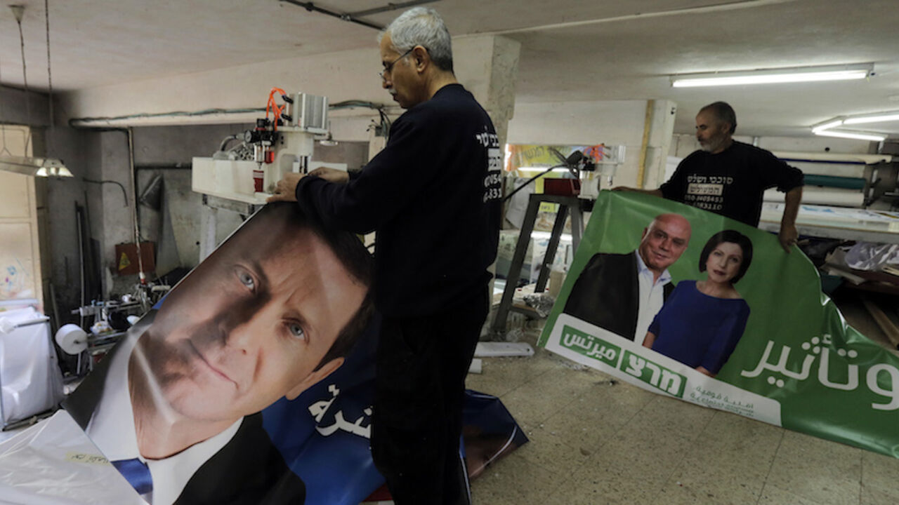 Workers hold freshly printed campaign banners in northern Israel Workers hold freshly printed campaign banners in Arabic that depict Isaac Herzog (L), who heads the centre-left Zionist Union alliance with former cabinet minister Tzipi Livni, and Zehava Galon (R), chair of the left-wing Meretz party, at a printing factory in the Arab village of Baqa al-Gharbiya in northern Israel March 2, 2015. Opinions polls show a tight race ahead of the March 17 election, campaigning for which has been dominated by economic issues like high living costs and workers wages. REUTERS/Ammar