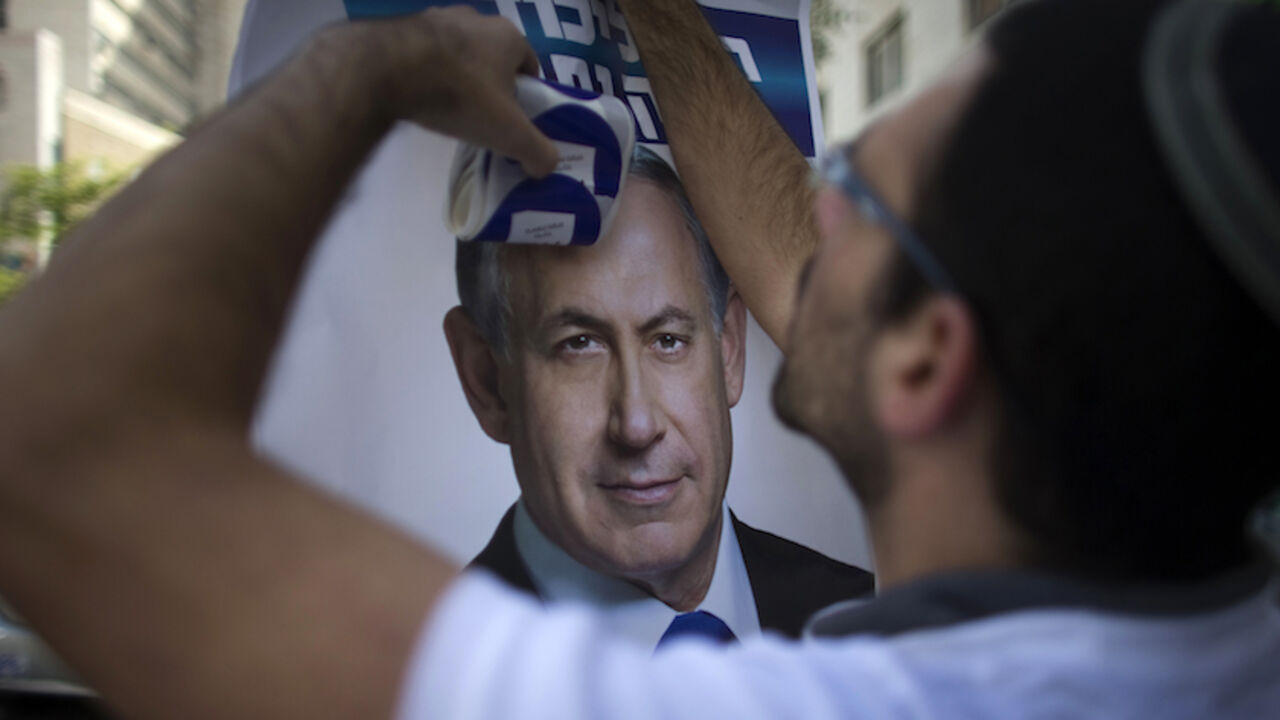 A Likud party supporter hangs a campaign poster depicting Prime Minister Benjamin Netanyahu in Jerusalem A Likud party supporter hangs a campaign poster depicting Prime Minister Benjamin Netanyahu in Jerusalem March 17, 2015. Millions of Israelis voted on Tuesday in a tightly fought election, with Netanyahu facing an uphill battle to defeat a strong campaign by the centre-left opposition to deny him a fourth term in office. REUTERS/Ronen Zvulun (JERUSALEM - Tags: POLITICS ELECTIONS) - RTR4TP77