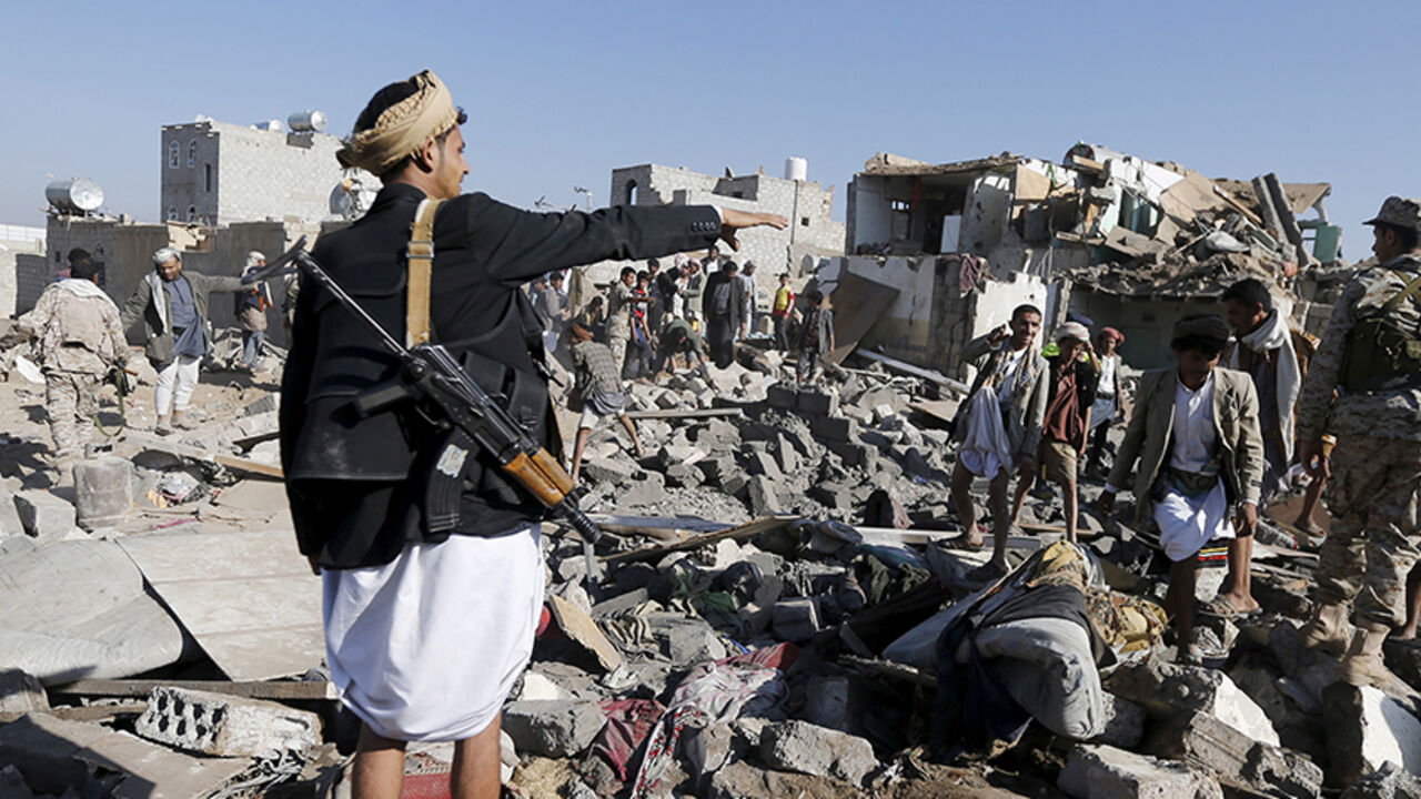 YEMEN-SECURITY/ An armed man gestures as he stands on the rubble of houses destroyed by an air strike near Sanaa Airport March 26, 2015. Saudi Arabia and Gulf region allies launched military operations including air strikes in Yemen on Thursday, officials said, to counter Iran-allied forces besieging the southern city of Aden where the U.S.-backed Yemeni president had taken refuge. REUTERS/Khaled Abdullah - RTR4UXIA