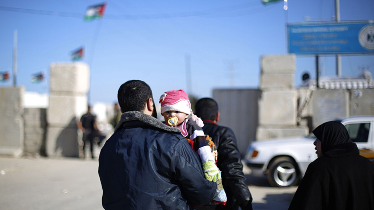 Nic6406240 A Palestinian man holds a child near the Erez crossing in Beit Hanun in the north of the Gaza Strip on January 13, 2015. The head of the Palestinian authority for civil affairs, Hussein al-Sheikh, said that Hamas have taken over the Palestinian side of the Erez Crossing, while the Islamic movement which controls the impoverished Palestinian territory has accused the Palestinian authority of stopping work at the crossing "without justification." AFP PHOTO / MOHAMMED ABED (Photo credit should read MOHA