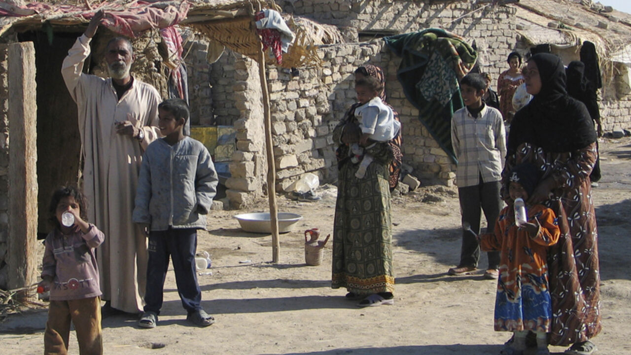 IRAQ GYPSIES Iraqi gypsy families gather outside their shack that serves as their home in the southern Iraqi city of Diwaniya January 4, 2006. Scorned by religious Muslims and barely tolerated by the rest of society, Iraq's Gypsies have a precarious existence. Lacking education or skills, they form one of the lower rungs of Iraq's social system. To match feature IRAQ GYPSIES REUTERS/Imad Al-Khozai - RTR17RDG