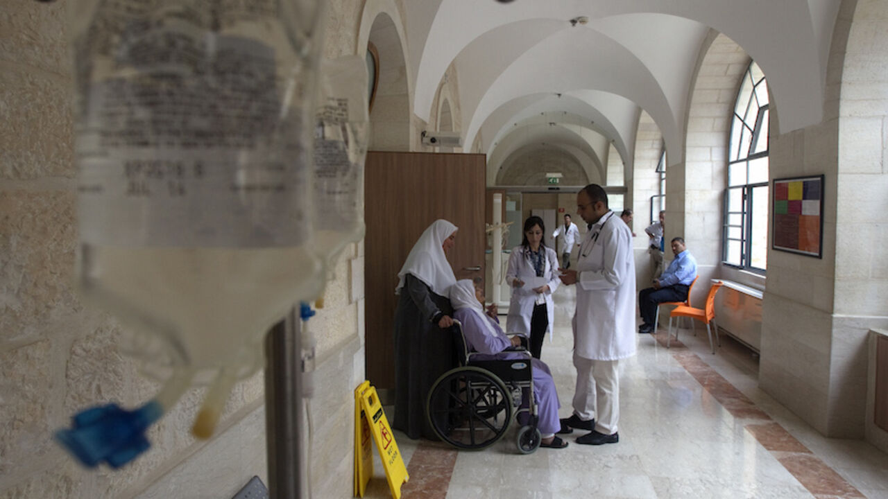 PALESTINIANS-ECONOMY/HOSPITALS Doctors speak to a Palestinian patient at Augusta Victoria Hospital in East Jerusalem November 6, 2012. Six hospitals in East Jerusalem face a financial crisis because the aid-dependent Palestinian Authority has been unable to meet payments for their services, jeopardizing the healthcare of thousands of West Bank patients. REUTERS/Baz Ratner (JERUSALEM - Tags: HEALTH POLITICS BUSINESS) - RTR3A2BZ
