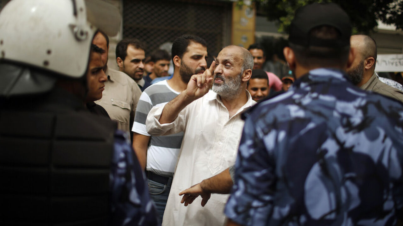 PALESTINIAN-UNITY/CRISIS A Palestinian employee (C) paid by the Palestinian Authority argues with employees appointed by Hamas since 2007, outside a closed bank in Gaza City June 5, 2014. A Palestinian unity government formed by President Mahmoud Abbas and the Islamist Hamas group faced its first and serious challenge on Thursday when civil servants of Hamas, who were not on the payment list, scuffled with those cashing their salaries. Civil servants employed by Hamas since 2007 arrived and prevented employees paid by the Palestini