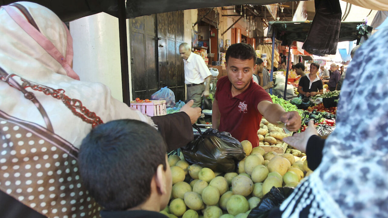 Palestinians shop at a market in Gaza City July 26, 2014. Palestinians in the Gaza Strip poured into the streets on Saturday to recover their dead and stock up on food supplies after a 12-hour humanitarian truce agreed by Israel and Hamas took hold. Israel's military pledged to hold fire for 12 hours from 8 a.m. (0500 GMT) but press on searching for tunnels used by militants. The Islamist group Hamas, which dominates Gaza, said all Palestinian factions would abide by the brief truce. REUTERS/Ahmed Zakot (GA