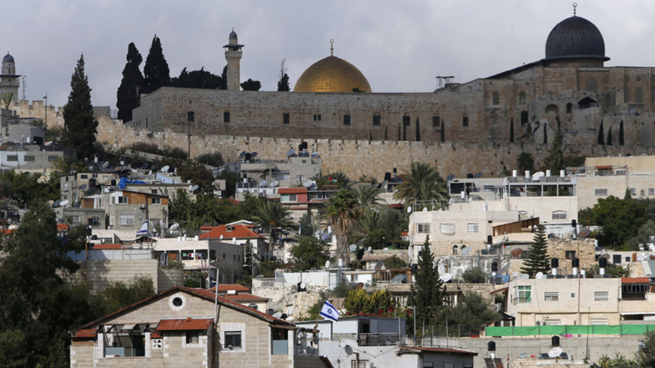 MIDEAST-JERUSALEM/VIOLENCE The Dome of the Rock and al-Aqsa mosque are seen in background as an Israeli flag flutters from atop a home of Jewish settlers in Silwan, a mostly Palestinian district abutting the Old City, November 3, 2014. For months, the streets of mainly Arab East Jerusalem, in the shadow of the Old City but where tourists seldom venture, have been ablaze, with daily clashes between armed Israeli police and Palestinians throwing rocks and Molotov cocktails.The roots of the unrest are many: from the killing in July of a