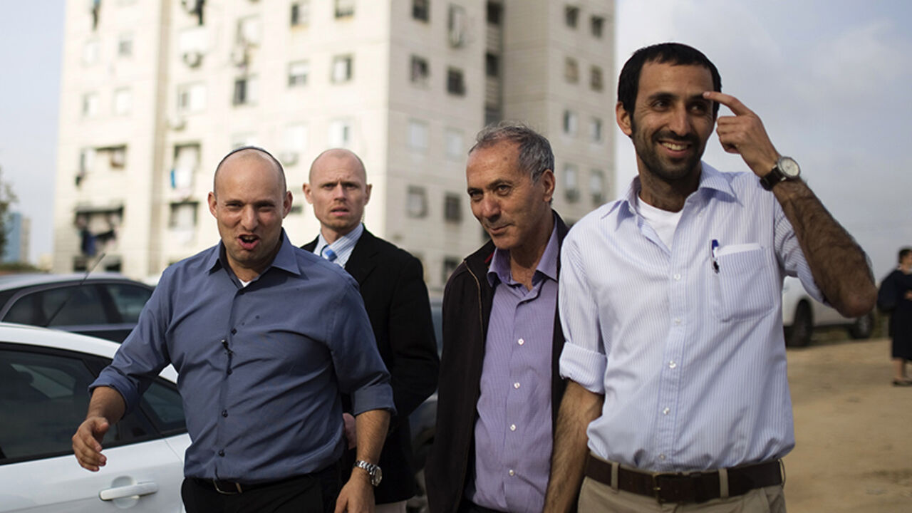 ISRAEL-ELECTIONS/BENNETT Israel's Economy Minister Naftali Bennett (L), head of far-right Jewish Home party, arrives at a shopping mall to campaign in the southern city of Ashkelon February 3, 2015. Young and ambitious, with a ready smile and a quick wit, Israeli far right leader Bennett is on a mission to prevent the creation of a Palestinian state. If, as widely expected, he takes on defence or another key portfolio after next month's election, that mission will take a big step closer to fulfilment, something his critics say coul