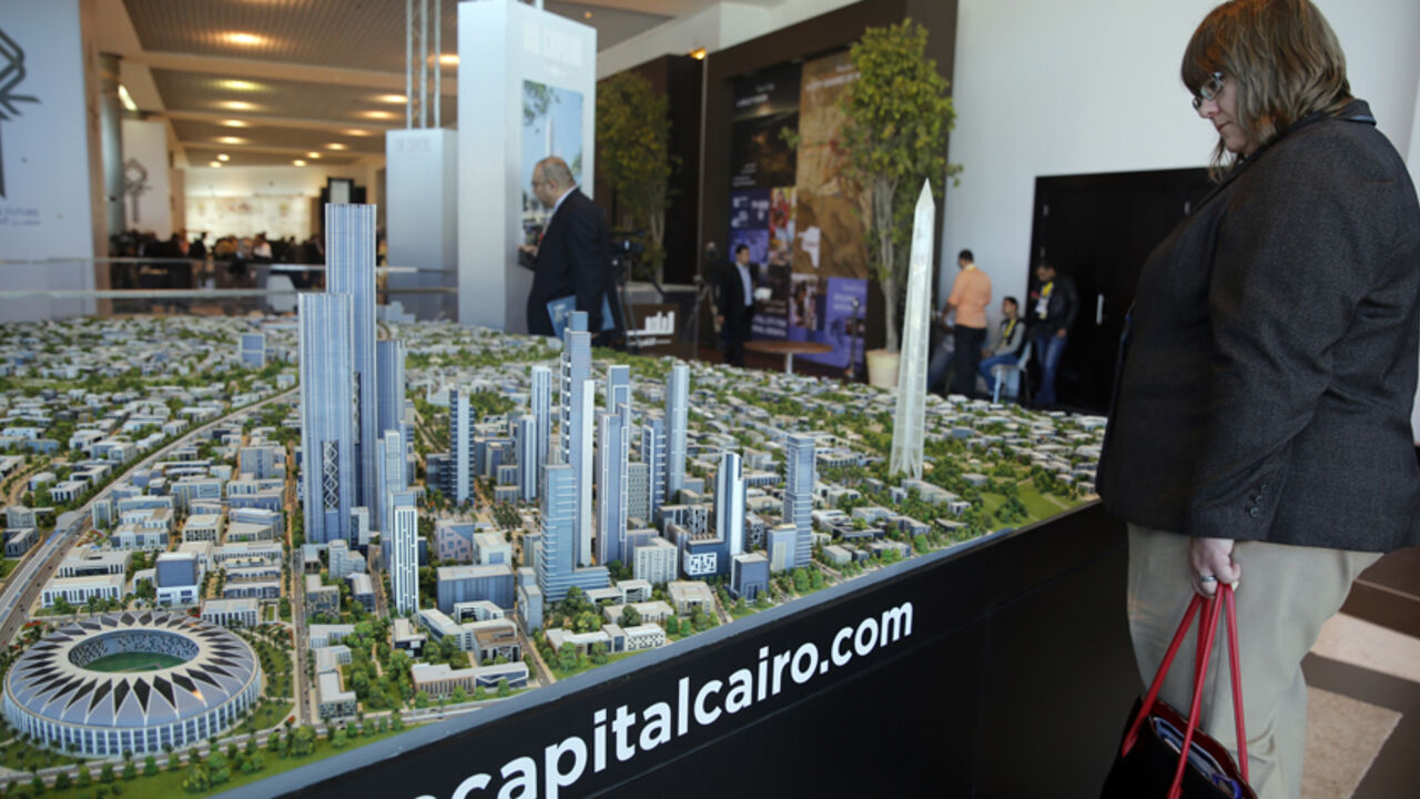 EGYPT-ECONOMY-INVESTMENT A delegate looks at a model of a planned new capital for Egypt during the final day of Egypt Economic Development Conference (EEDC) in Sharm el-Sheikh, in the South Sinai governorate, south of Cairo, March 15, 2015. President Abdel Fattah al-Sisi was so confident after Egypt signed billions of dollars of deals at an investment summit that he publicly joked on Sunday about haggling with the world's top chief executives. Yet the real challenge has only just begun. REUTERS/Amr Abdallah Dalsh (EGYPT - Tags: BU