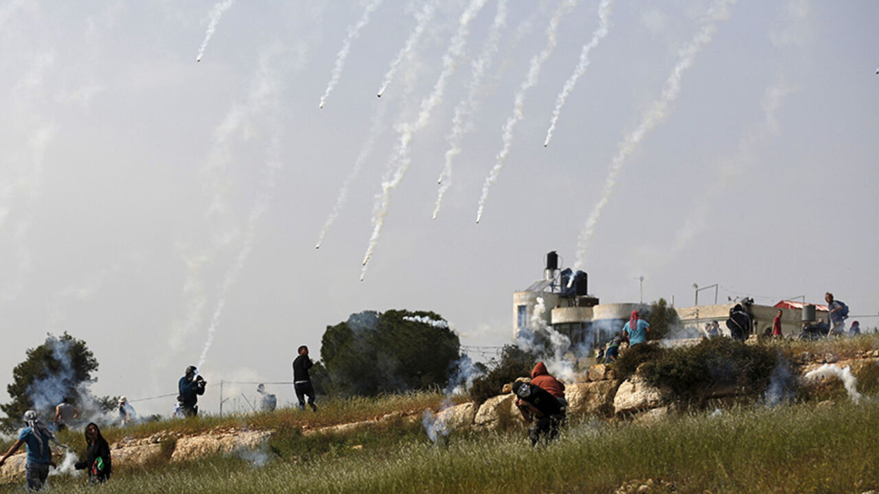 ISRAEL-PALESTINIANS/ Palestinian protesters run from tear gas canisters launched by Israeli troops during clashes following a protest marking the Land Day, in the West Bank village of Nabi Saleh near Ramallah March 28, 2015. Palestinians marks Land Day on March 30, the annual commemoration of protests in 1976 against Israel's appropriation of Arab-owned land in the Galilee. REUTERS/Mohamad Torokman TPX IMAGES OF THE DAY - RTR4V9NG