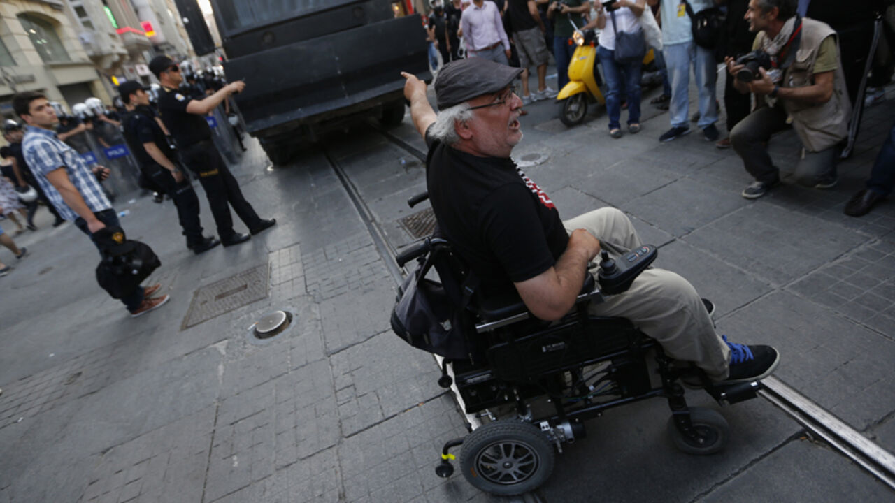 TURKEY-PROTESTS/POLICE A demonstrator on a wheelchair blocks an armoured police vehicle on Istiklal Street in central Istanbul July 13, 2013. Turkish police fired water cannon and tear gas on Saturday to disperse hundreds of protesters who gathered to march to Gezi Park, which has been at the heart of fierce unrest against Prime Minister Erdogan's rule. Protesters scattered, running into sidestreets where police pursued them, before starting to regroup on Istiklal Street, metres from the main Taksim Square. REUTERS/Umit Bektas (T