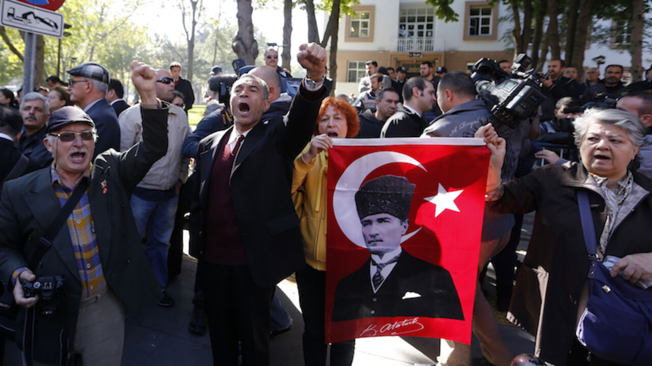 TURKEY-COUP/VERDICT Relatives of detained military officers hold a portrait of Mustafa Kemal Ataturk, founder of modern Turkey, and shout slogans in front of a courthouse in Ankara October 9, 2013. Turkey's appeals court upheld convictions on Wednesday of top retired military officers for leading a plot to overthrow Prime Minister Tayyip Erdogan's government a decade ago in a case underlining civilian dominance over a once all-powerful army. The court overturned convictions of dozens of less prominent defendants among more th